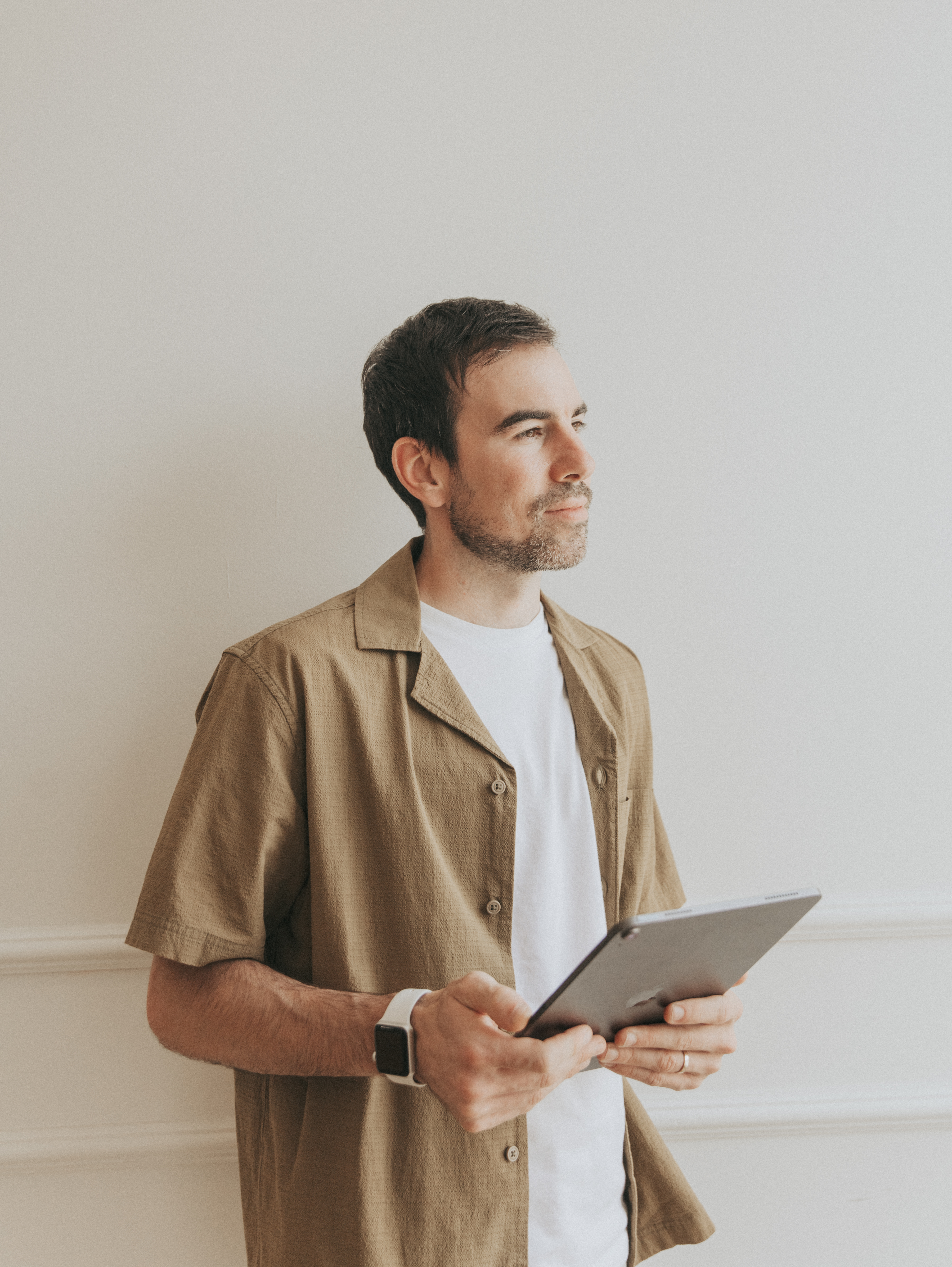 David Sherry standing beside a window with a tablet